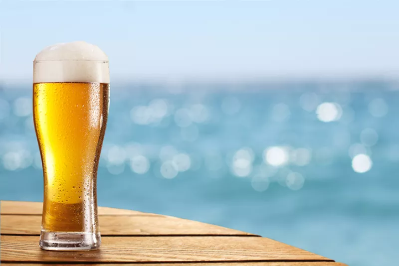 Beer glass on a blurred background of sea.
