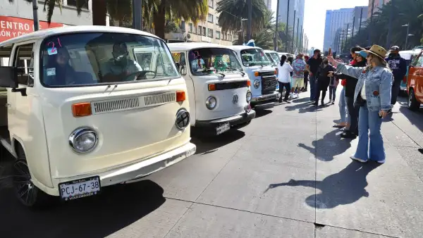 Personas toman fotos a distintos modelos de la VW Combi.