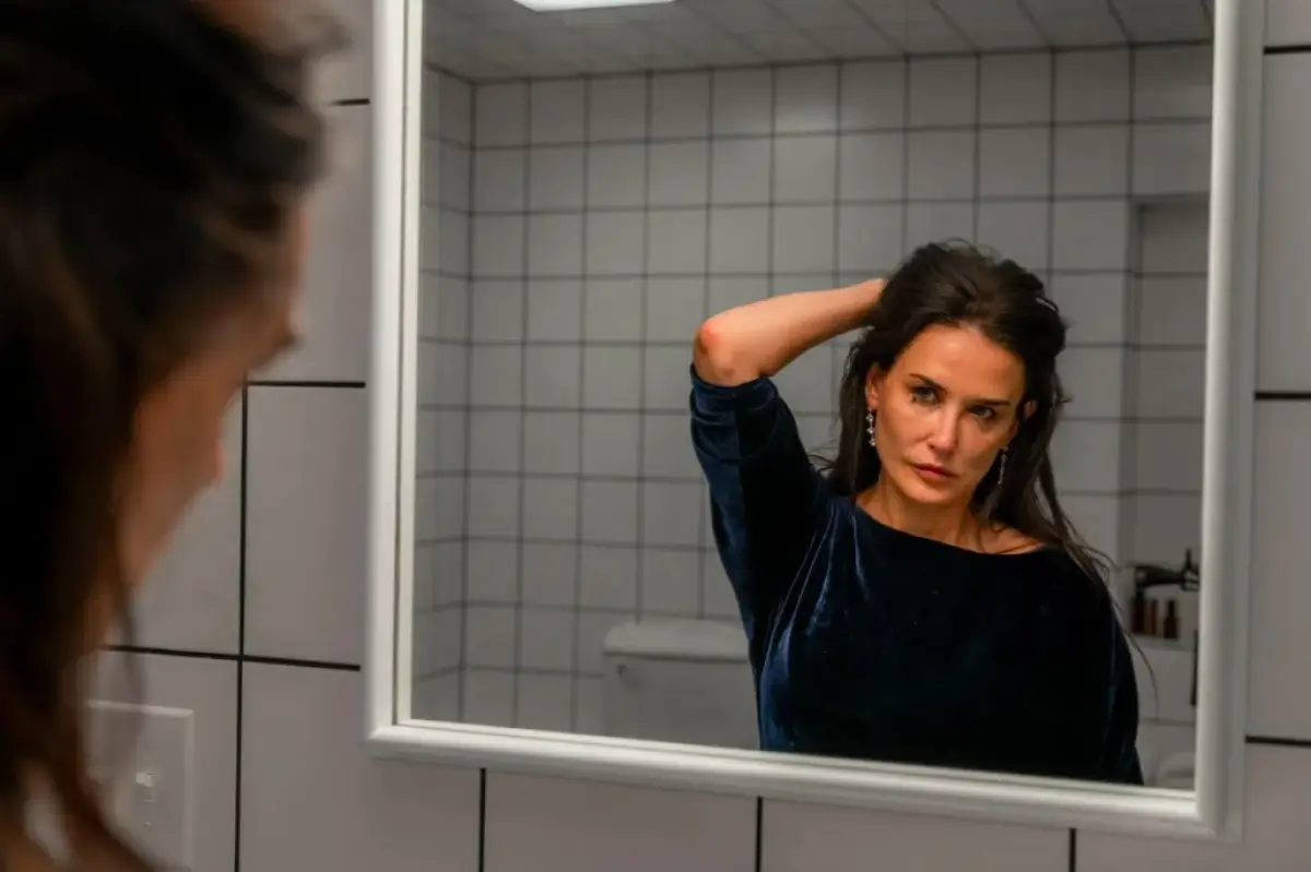 Foto de Demi Moore en una escena de la película The Substance donde se le ve frente al espejo.
