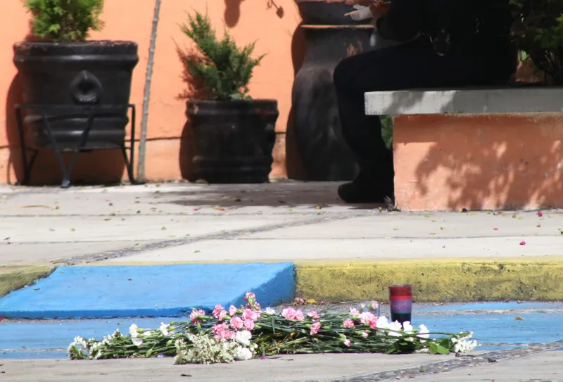Un ramo de flores y una vela en el lugar del homicidio de la estudiante española Claudia Tacoronte 
