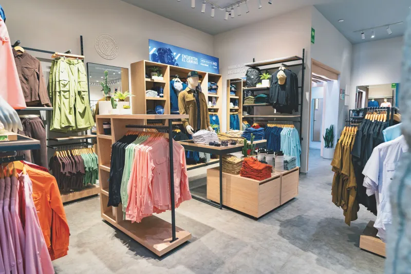 Una tienda de MAJA Sportsware en donde se muestran diferentes tipos de ropa especializada para actividades al aire libre, como pesca deportiva o senderismo.