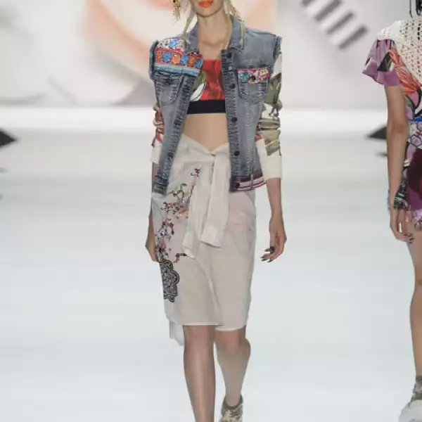 Chaleco de denim, blusa de algodón en la cintura sobre crop top y shorts de spandex. Sandalias de plataforma.