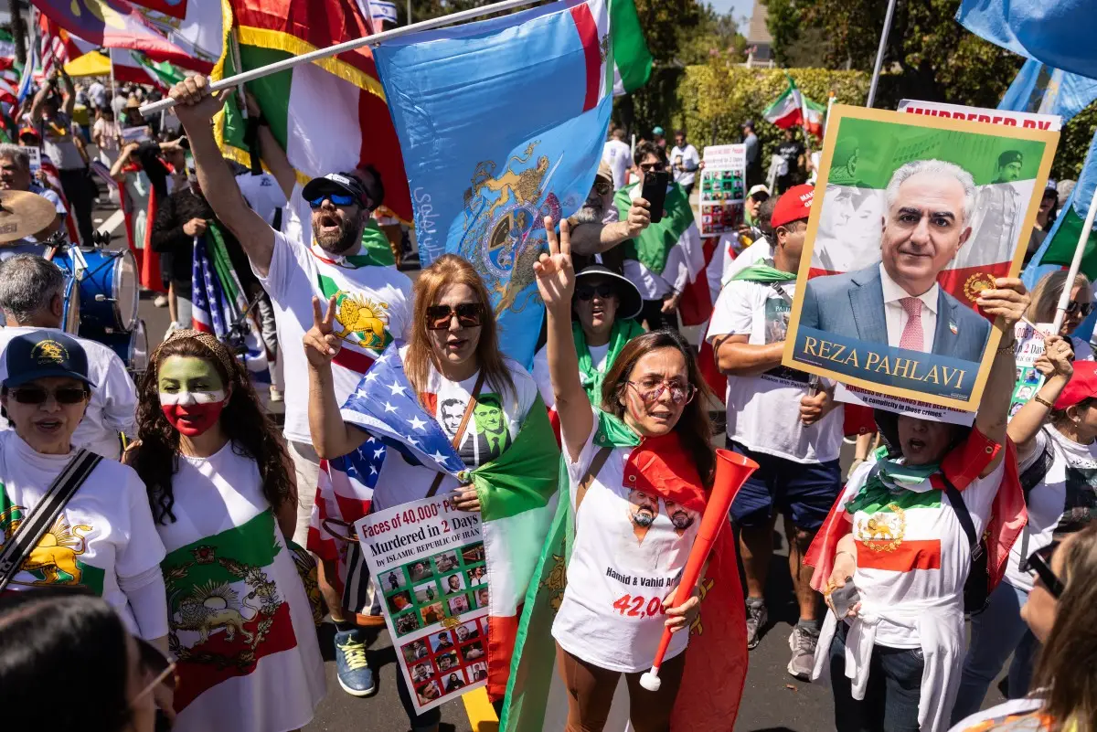 Un manifestante sostiene un cartel con un retrato del hijo del último sha de Irán, Reza Pahlavi, mientras la gente se manifiesta contra el régimen iraní fuera del Estadio de Los Ángeles (Estadio SoFi) antes del partido del torneo de fútbol americano de la Copa Mundial de 2026 entre Irán y Nueva Zelanda en Inglewood, California, el 15 de junio de 2026.