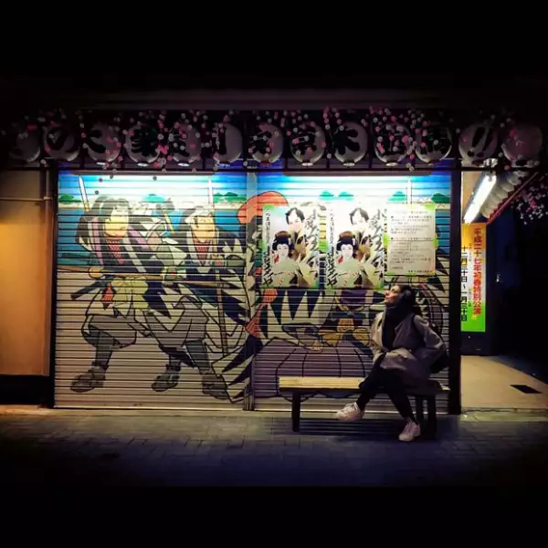 La actriz en un local japonés con publicidad nipona.