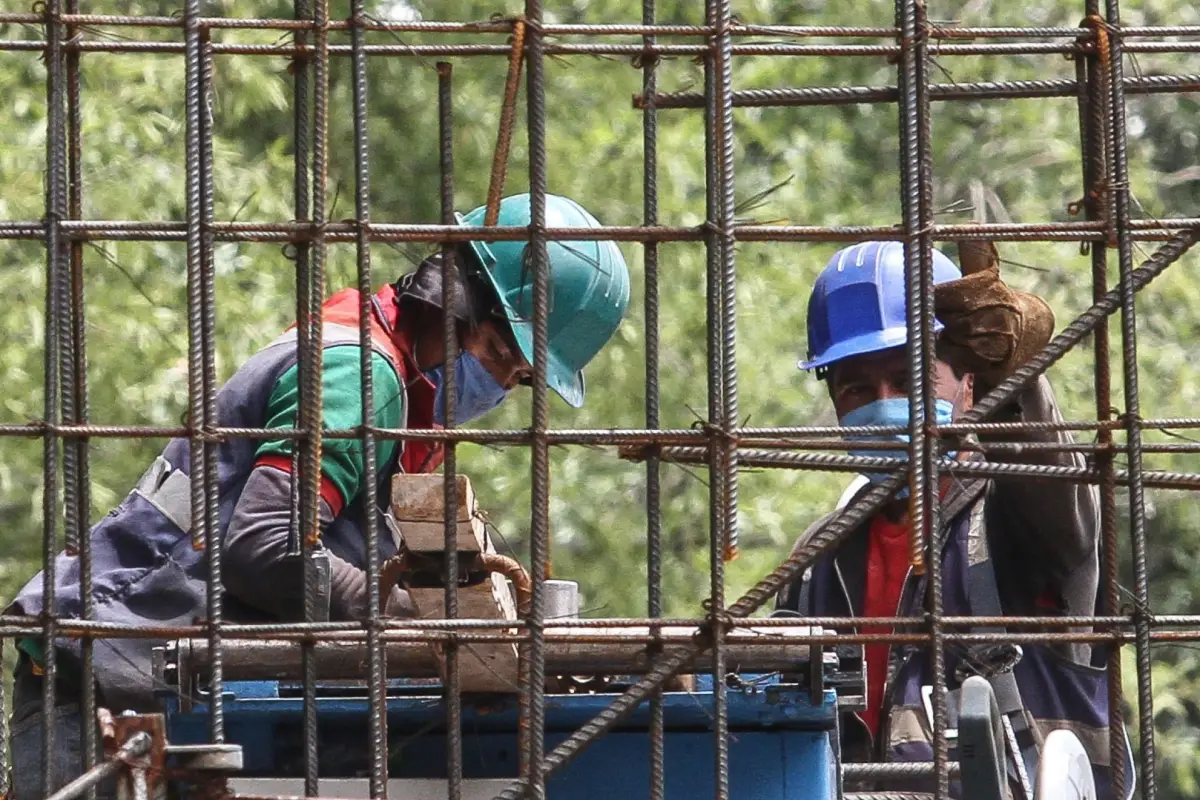 Dos trabajadores de la construcción ajustan varillas en CDMX.