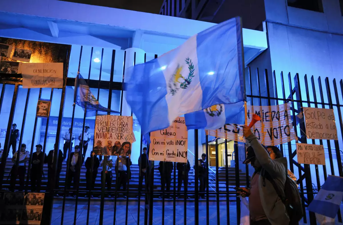 Un partidario del candidato presidencial Bernardo Arevalo del partido político Semilla sostiene una bandera guatemalteca cerca del Ministerio Público, en la Ciudad de Guatemala, Guatemala, el 13 de julio de 2023.
