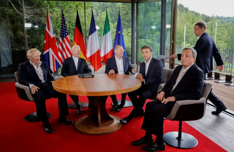 El canciller alemán Olaf Scholz, (3rdL) recibe una carpeta mientras (L-R) el primer ministro británico Boris Johnson, el presidente estadounidense Joe Biden, el presidente francés Emmanuel Macron y el primer ministro italiano Mario Draghi esperan el inicio de su reunión de cinco líderes del G7 en junio 28 de febrero de 2022 en el Castillo de Elmau, en el sur de Alemania, el último día de la Cumbre del G7.