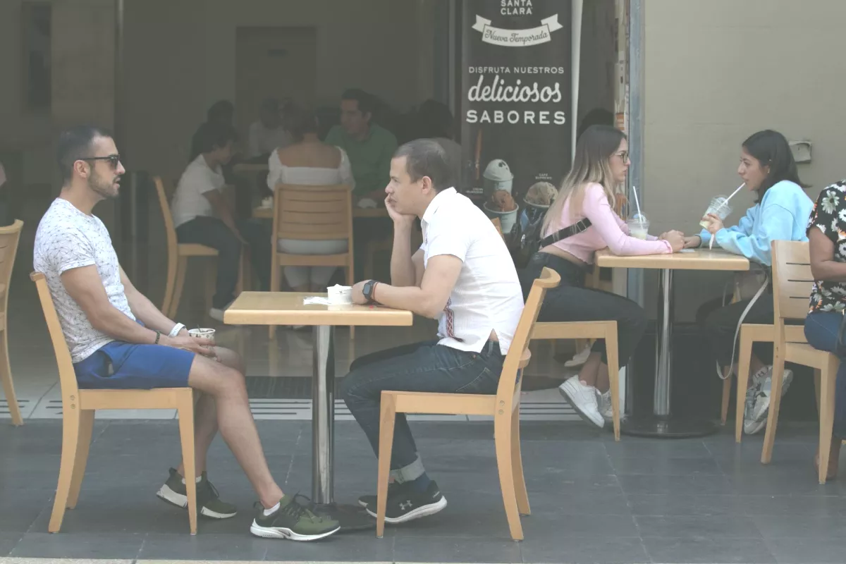 Dos parejas sentadas en mesas de banqueta en un restaurante de la Ciudad de México.