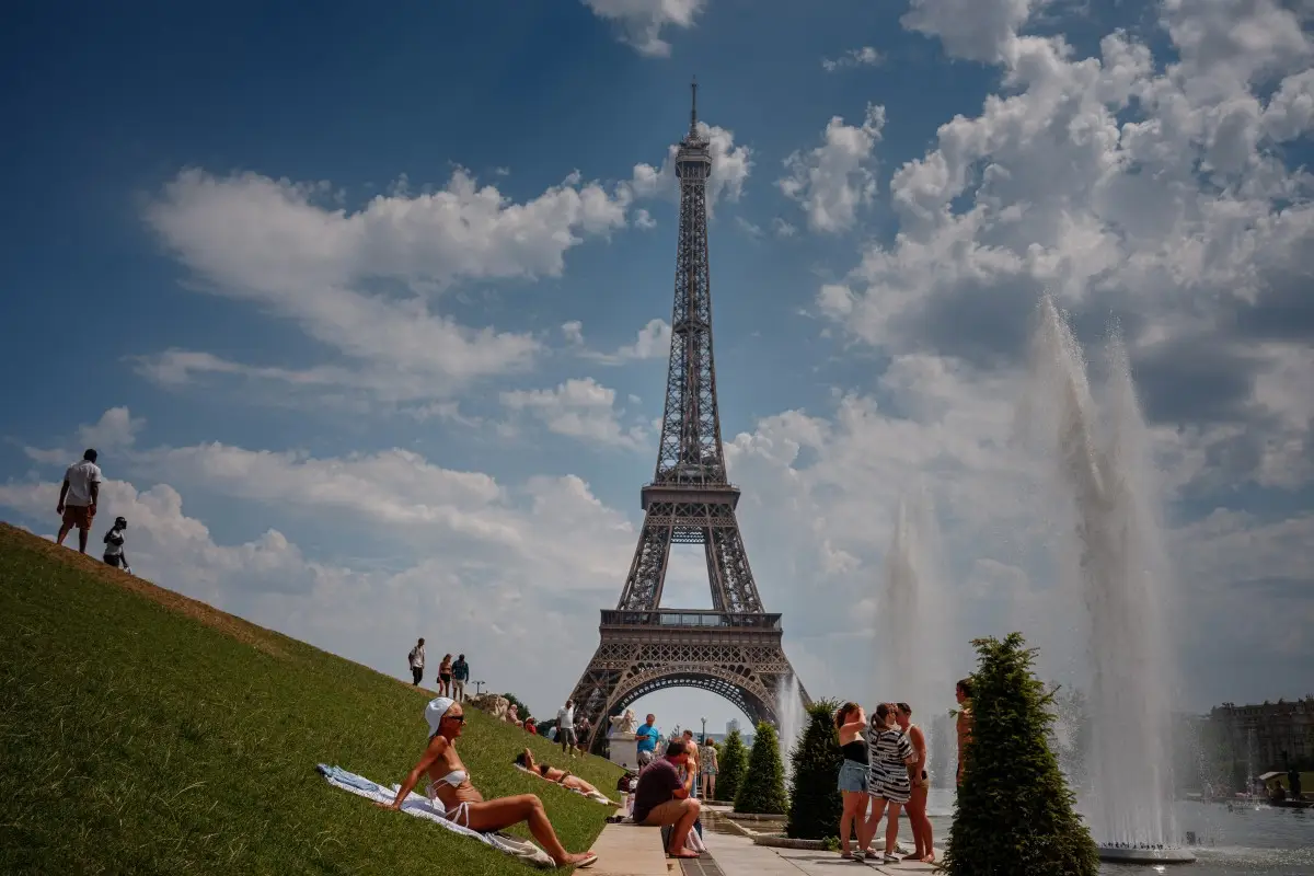 La gente se enfría cerca de la Fuente del Trocadero con la Torre Eiffel de fondo durante una ola de calor en París el 26 de junio de 2026.