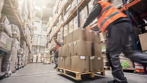 Motion blur of two men moving boxes in a warehouse
