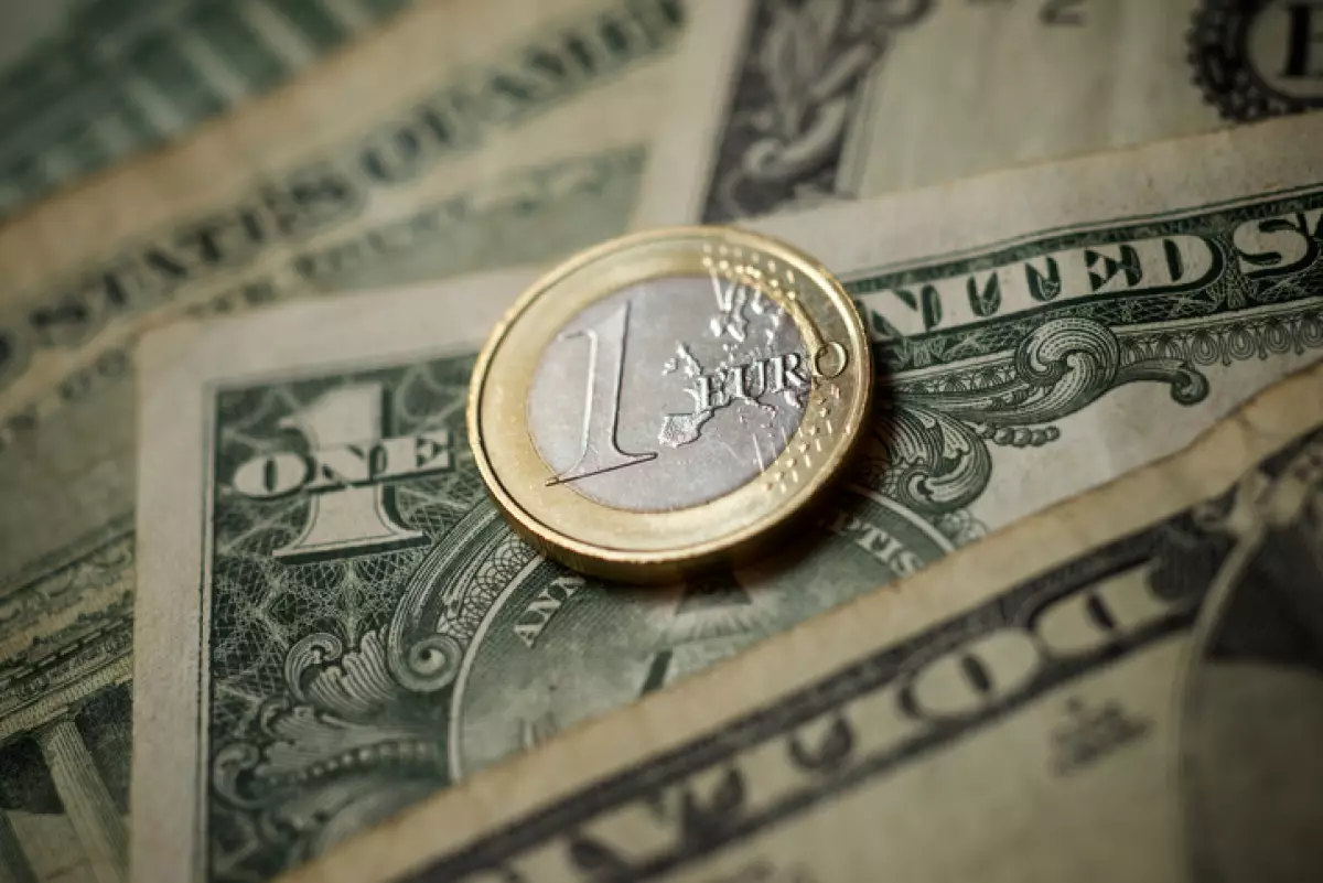 moneda de un euro sobre billete de un dolar