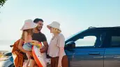 Familia feliz que se prepara para unas vacaciones de verano en una carretera junto a la playa.