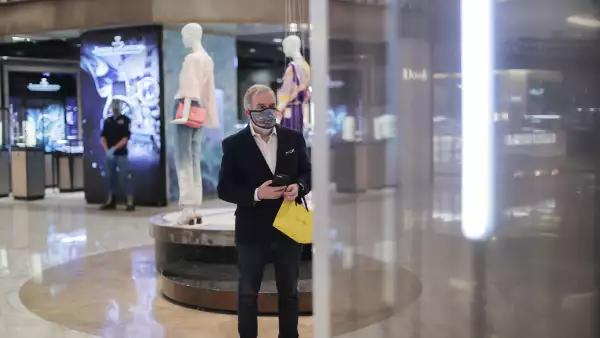 (Un hombre lleva una bolsa de compra, en la tienda departamental Palacio de hierro)