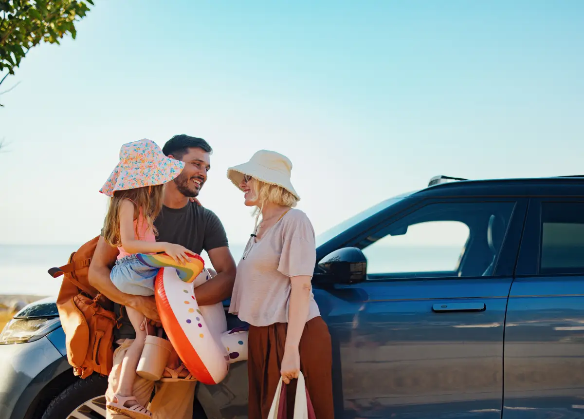 Familia feliz que se prepara para unas vacaciones de verano en una carretera junto a la playa.