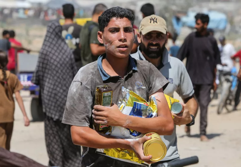 Los palestinos recogen paquetes de ayuda que fueron lanzados por el aire, en medio de una crisis de hambre, en Zawayda, en la Franja de Gaza central, el 31 de julio de 2025.