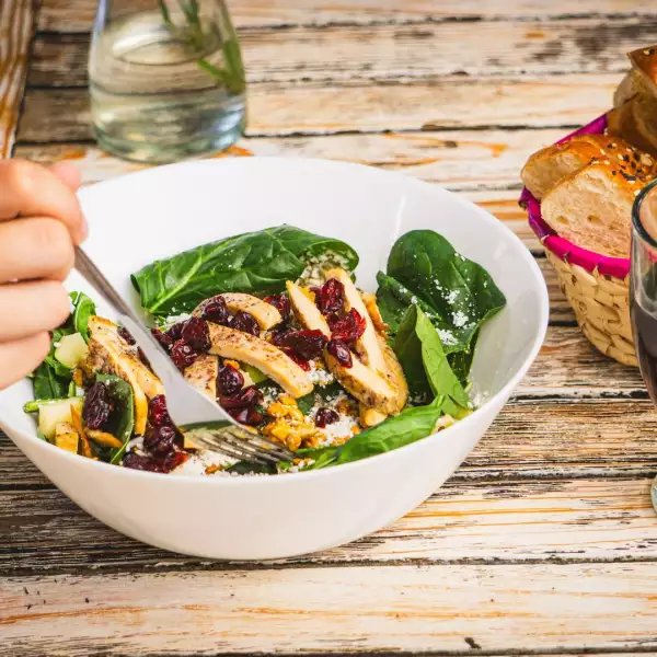 foto de plato de ensalada de pollo con espinacas frescas y arándanos.