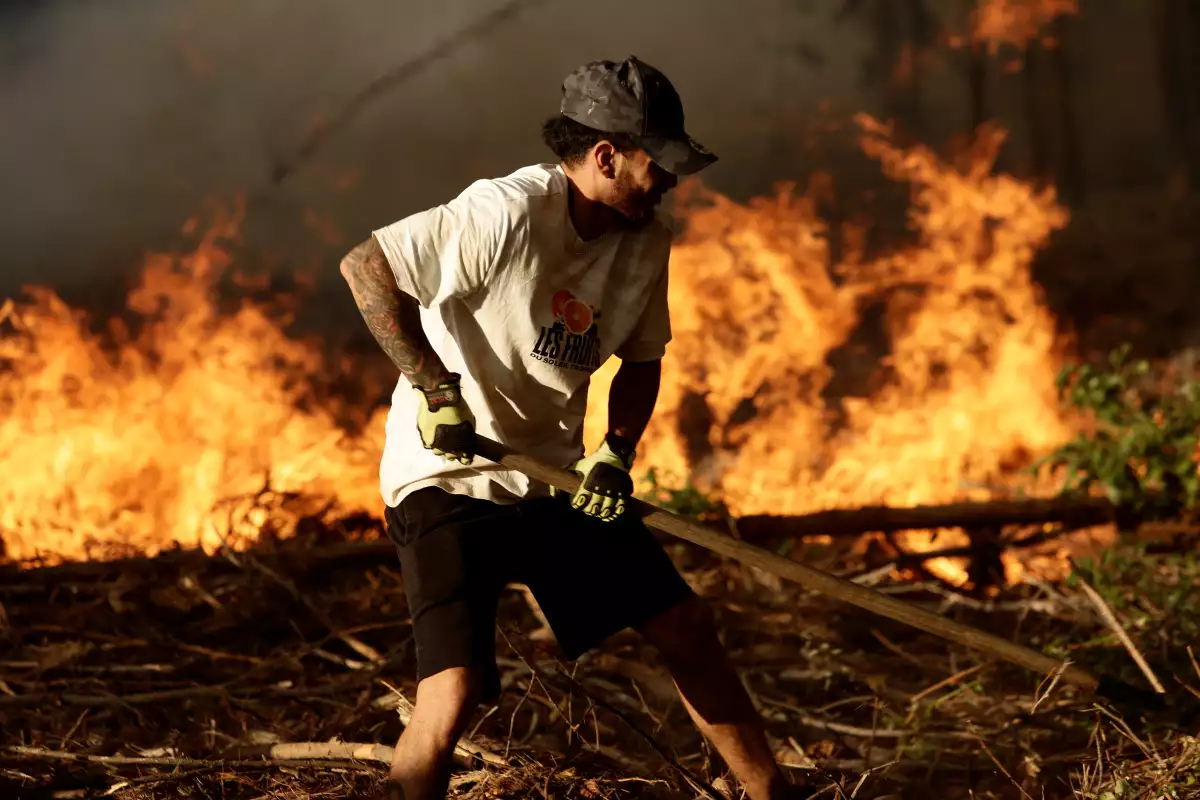 Un residente local lucha durante un incendio forestal en Rafael, cerca de Concepción, Chile. 