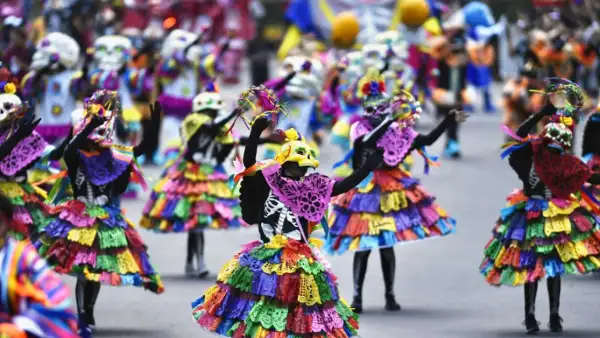 Personas con papel picado como vestidos y máscaras de calavera.jpg