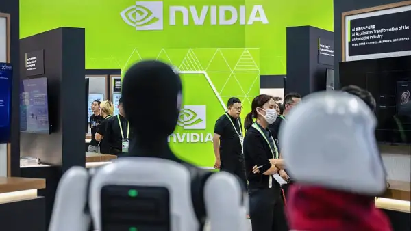 Gente y robots caminando por el booth de Nvidia en una convención de tecnología en China. De fondo, el logo de la empresa.