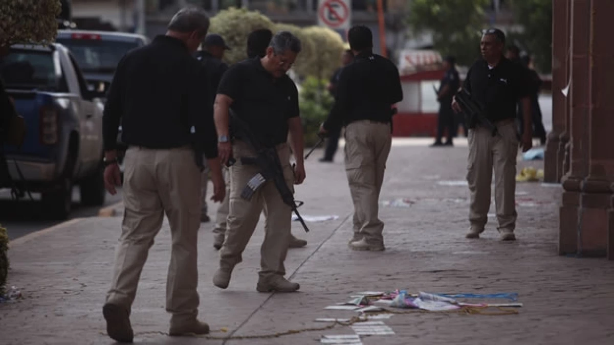 Elementos de seguridad inspeccionan el lugar donde murieron varias personas en un enfrentamiento con fuerzas federales