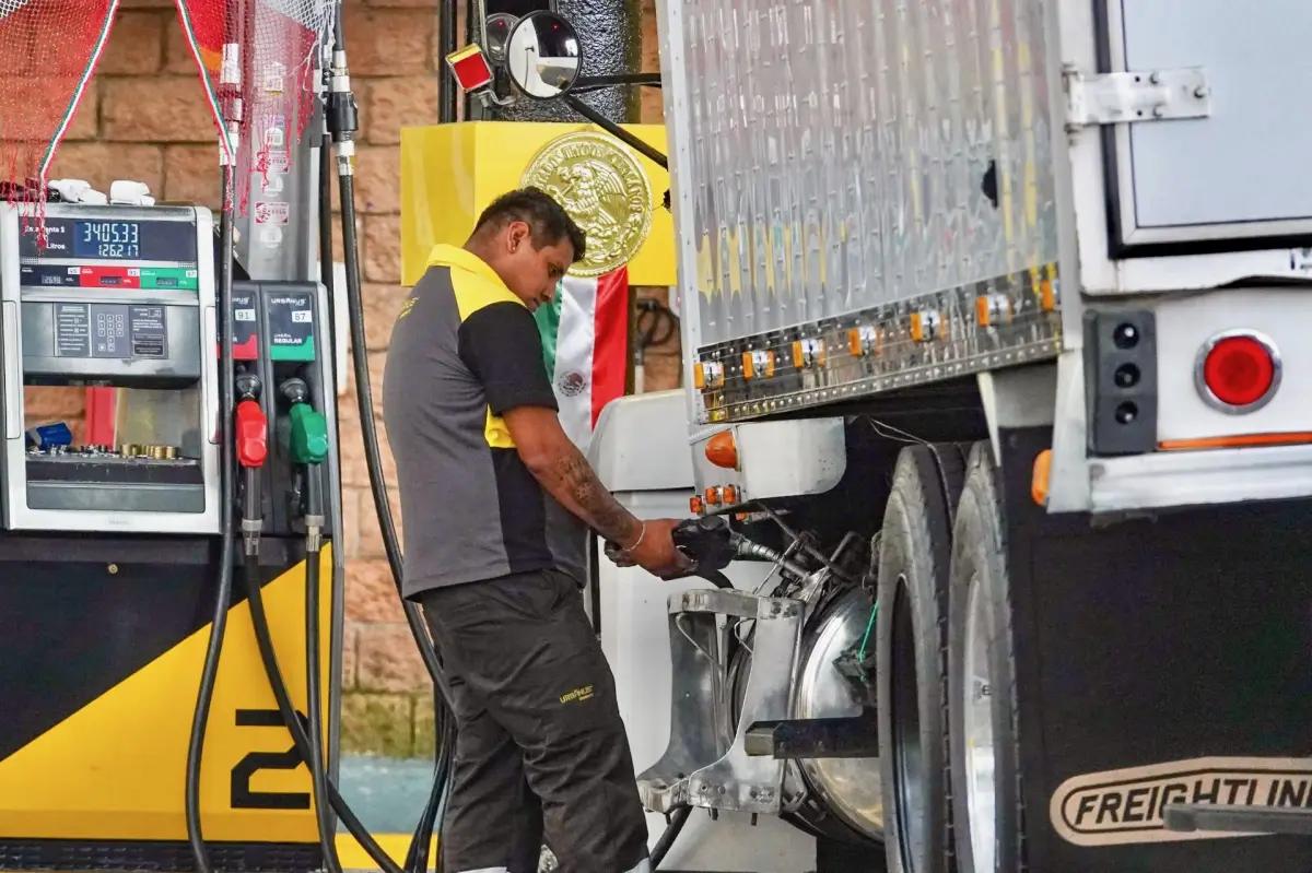 Un despachador de combustible en una gasolinera despacha diésel, un combustible fósil que podría sustituirse por biodiésel.