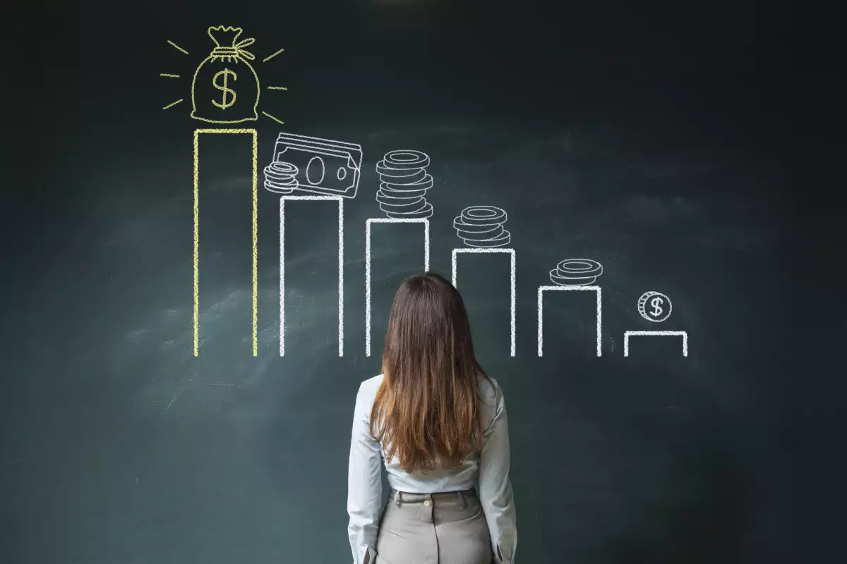 Mujer viendo un pizarrón con gráficos de ahorro. Estas son tres opciones para ahorrar 70 mil pesos
