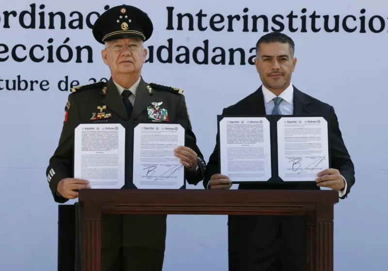En la imagen, los  secretarios Omar García Harfuch y Ricardo Trevilla sostienen el convenio tras la firma. 