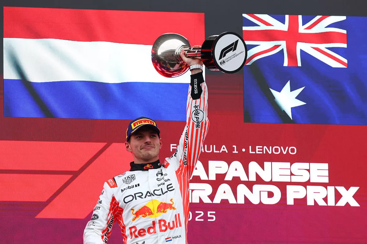 Foto de Max Verstappen con la bandera de Países Bajos detrás y alzando el trofeo del Gran Premio de Japón.
