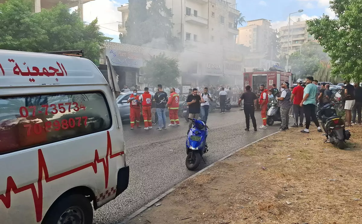 El humo se eleva de una tienda móvil mientras los miembros de la defensa civil se reúnen en Sidon, Líbano, el 18 de septiembre de 2024.