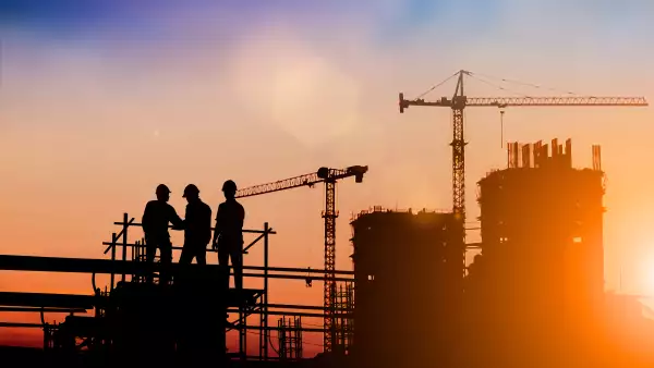 Silhouette of engineer and construction team working at site over blurred background for industry background with Light fair.Create from multiple reference images together