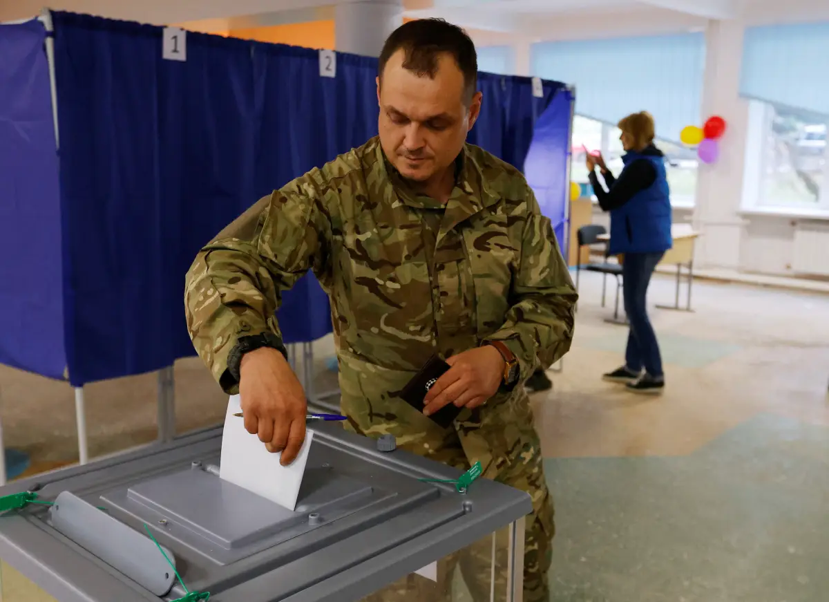 Un hombre vestido de militar vota