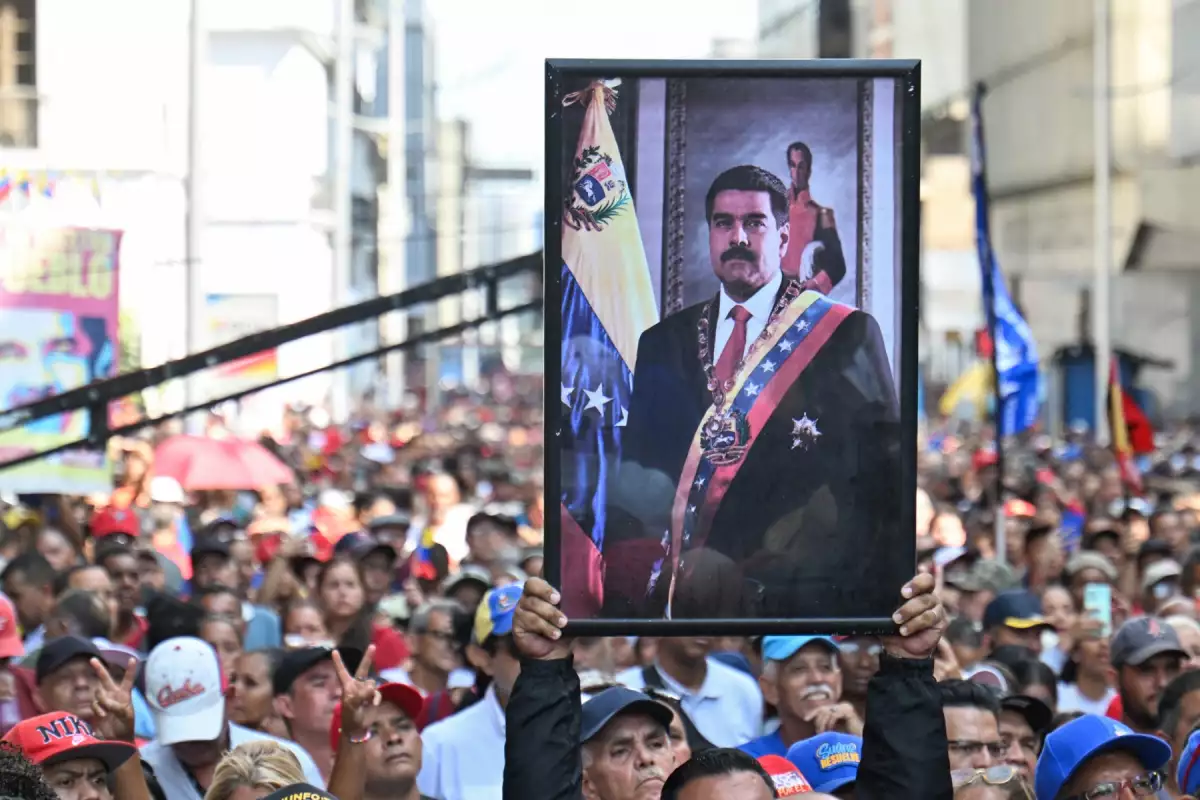 Un partidario del derrocado presidente venezolano Nicolás Maduro lleva su retrato durante un mitin fuera de la Asamblea Nacional en Caracas el 5 de enero de 2026.