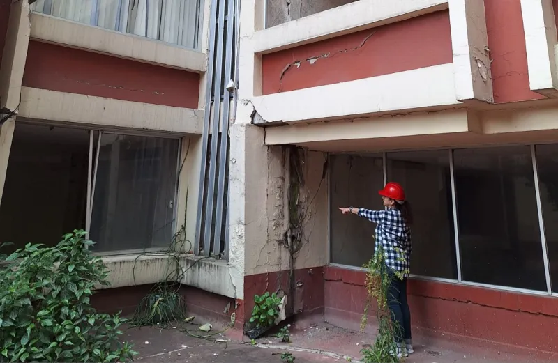 Una mujer muestra los daños en una columna de Aguascalientes 12, Roma Sur, donde 70 departamentos dañados por el sismo del 19 de septiembre de 2017 aún no son reconstruidos.