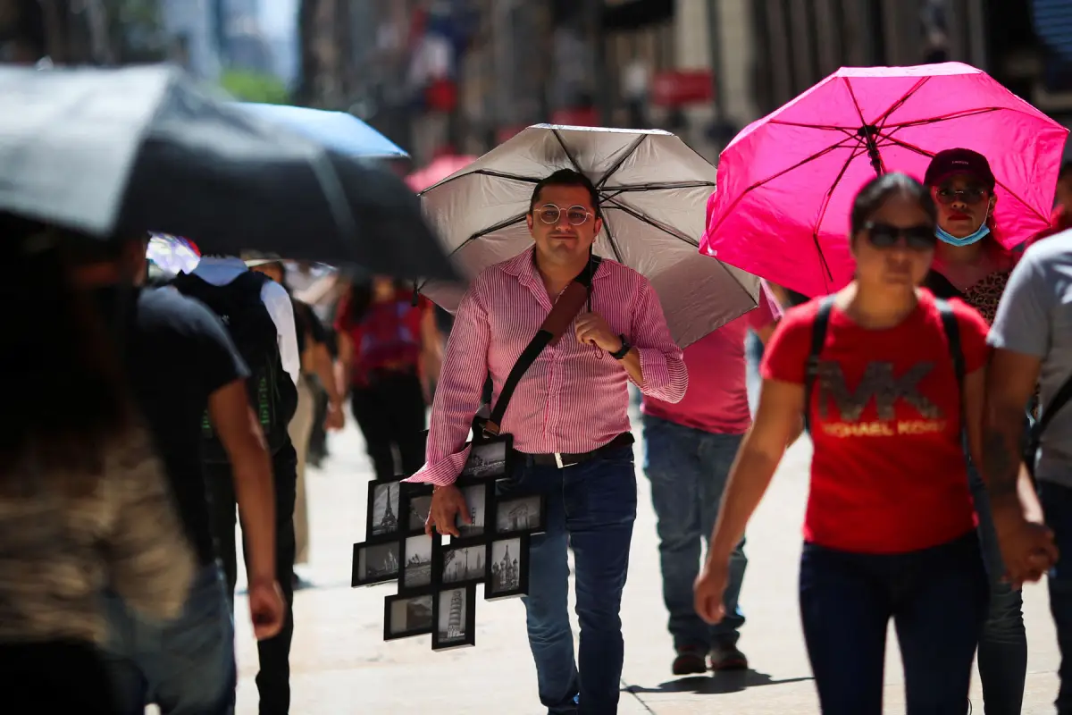 People walk during a period of high temperatures in Mexico City