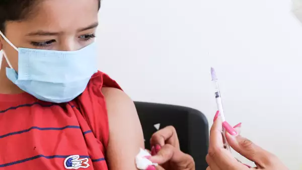 (Niño a punto de ser vacunado contra Covid-19)