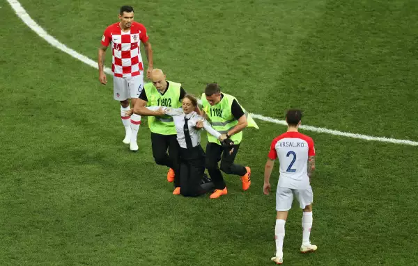 Un invasor de campo es retirado del campo mientras Dejan Lovren y Sime Vrsaljko miran durante la final de la Copa Mundial de la FIFA Rusia 2018 entre Francia y Croacia en el Estadio Luzhniki el 15 de julio de 2018 en Moscú, Rusia.