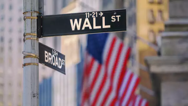 Wall Street Sign in New York With American Flags in the Background