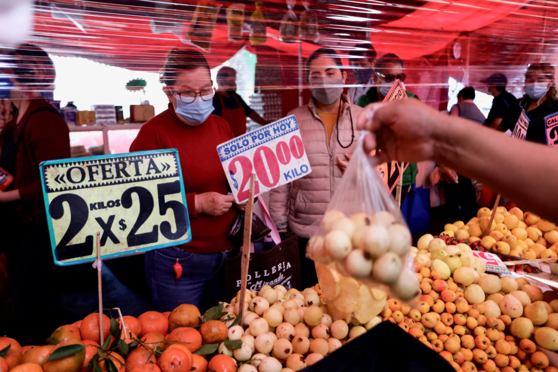 (Mujeres compran verduras en un mercado)