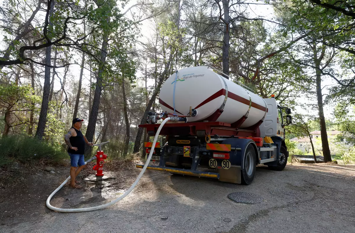 Daniel Martel fills the tank of his truck with water in order to supply it to the villages of the area, as an historical drought hits France, in Fayence