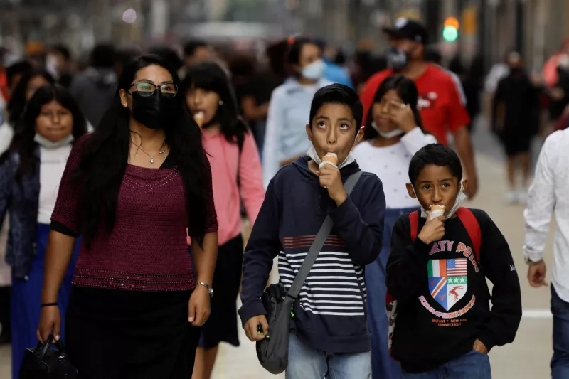 Niño come un helado mientras camina en una zona comercial en una calle concurrida de la Ciudad de México. 