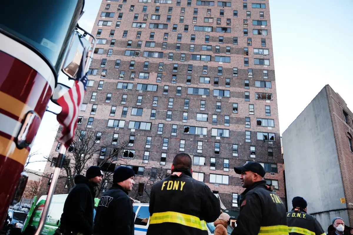 Bomberos se reúnen frene a un edificio de epartamento en el Bronx, Nueva York un día después de que un incendio azotó al complejo provocando la muerte de al menos 19 personas e hiriendo a decenas más. 