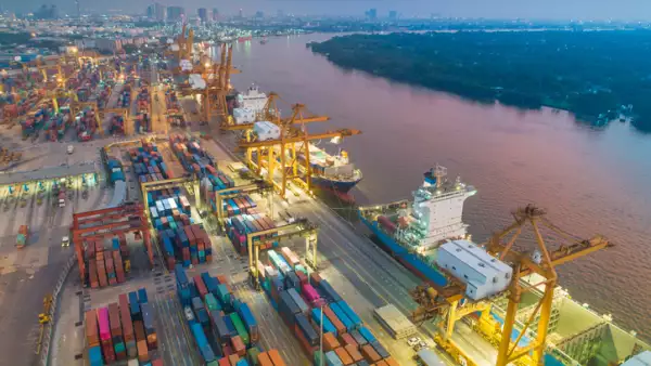 Logistics and transportation of Container Cargo ship and Cargo with working crane bridge in shipyard at sunrise, logistic import export and transport industry background