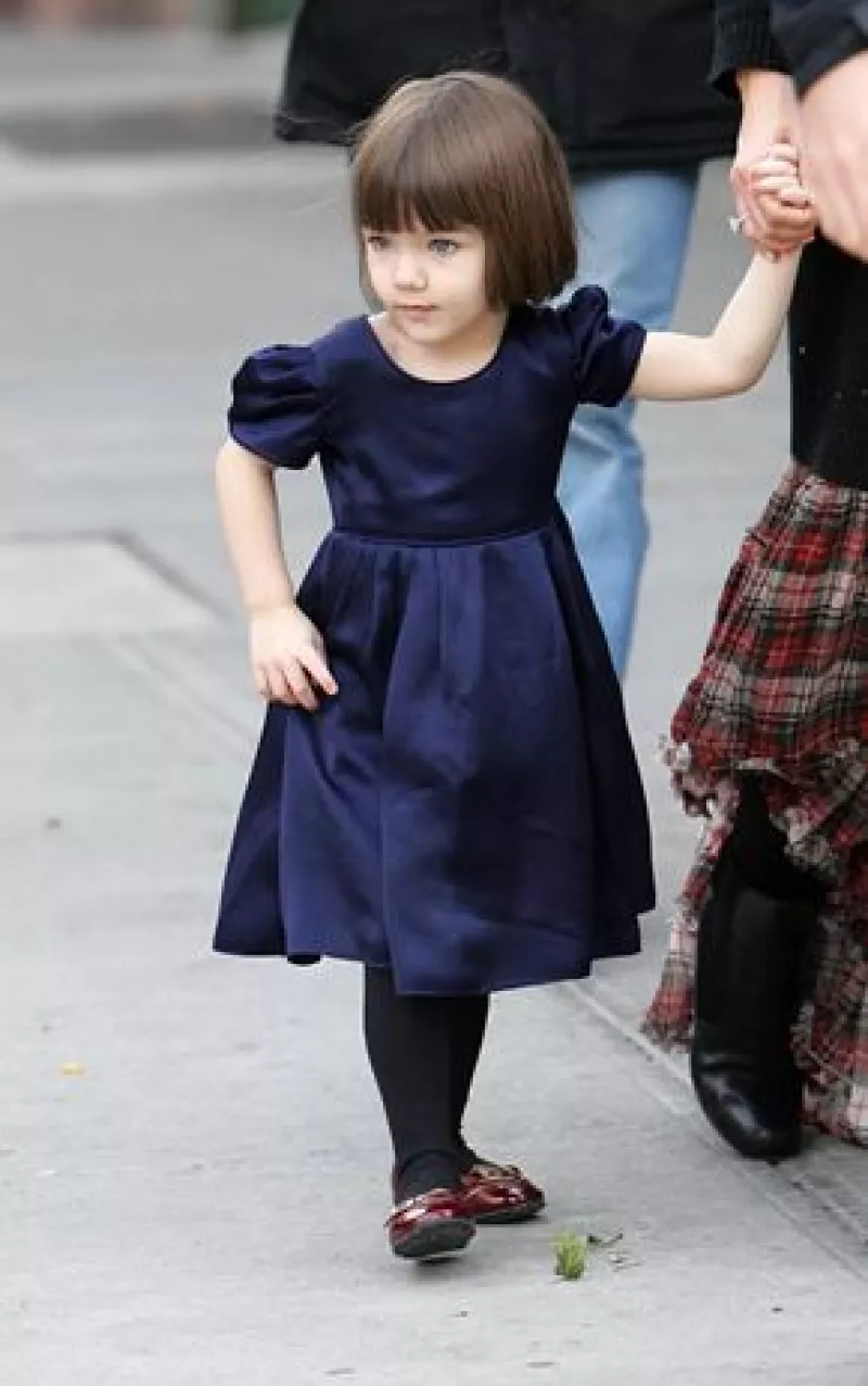 La hija de Tom y Katie se quita los pantalones cuando intentan ponérselos.