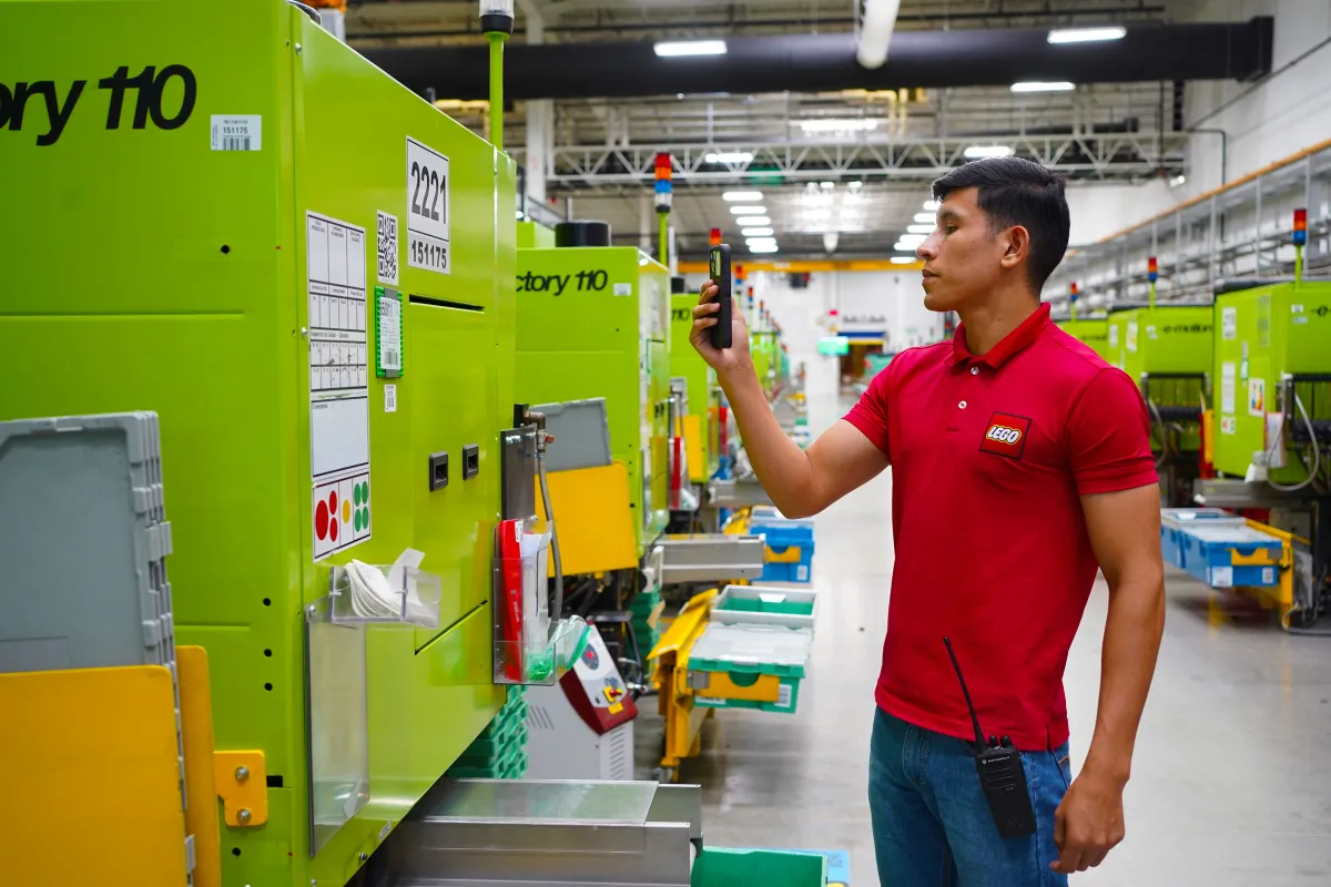 Trabajador de LEGO opera maquinaria en una planta de manufactura de la empresa en Nuevo León.