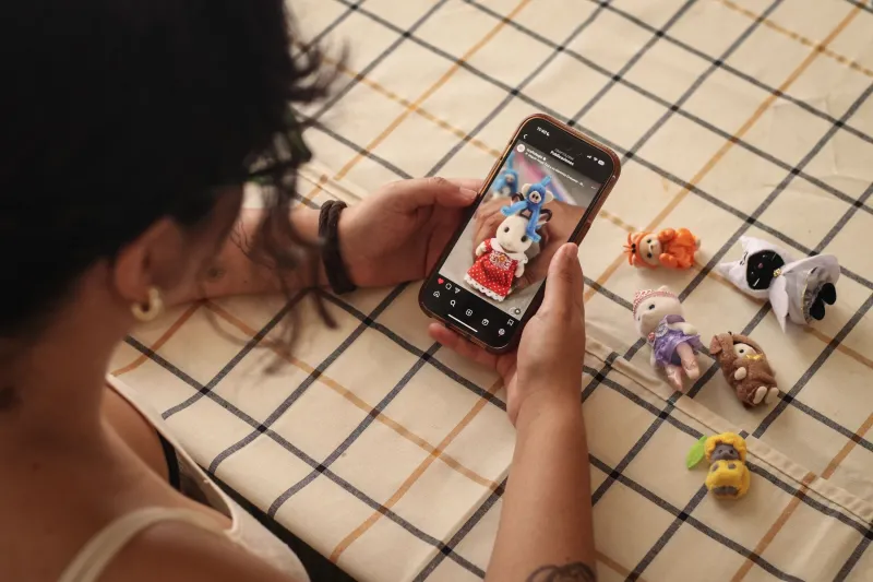 Una joven sostiene un celular entre sus manos.