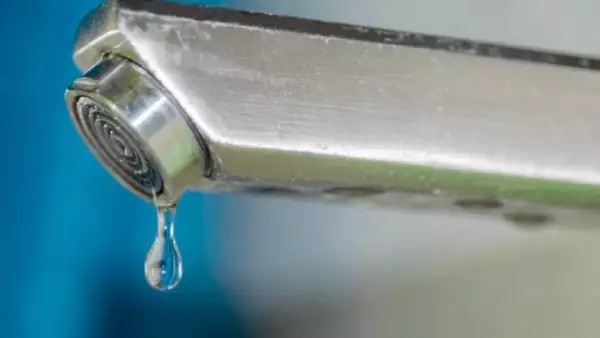 Una gota de agua sale de una llave.