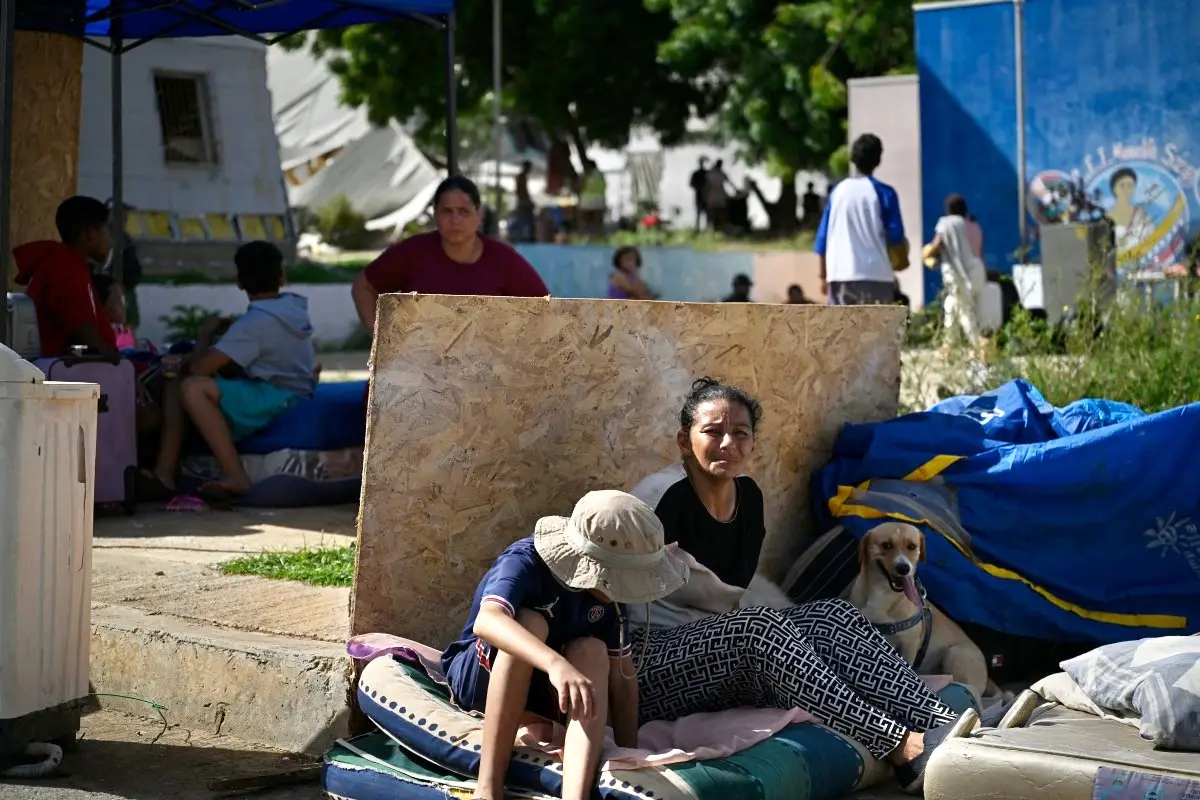 Los residentes se sientan junto a sus pertenencias mientras se refugian en una calle después de un terremoto en Catia La Mar, estado de La Guaira, a unos 30 km al noroeste de Caracas, el 25 de junio de 2026.