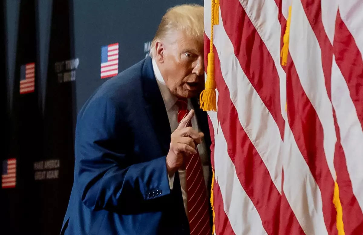 El expresidente de los Estados Unidos y candidato presidencial republicano Donald Trump actúa confundido en el escenario mientras se hace pasar por el presidente de los Estados Unidos Joe Biden durante un evento de campaña, en Clinton, Iowa, EE. UU., el 6 de enero de 2024.