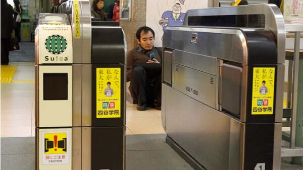 Un hombre se sienta en el suelo de una estación de trenes, luego de que los servicios de metro fueron suspendidos.