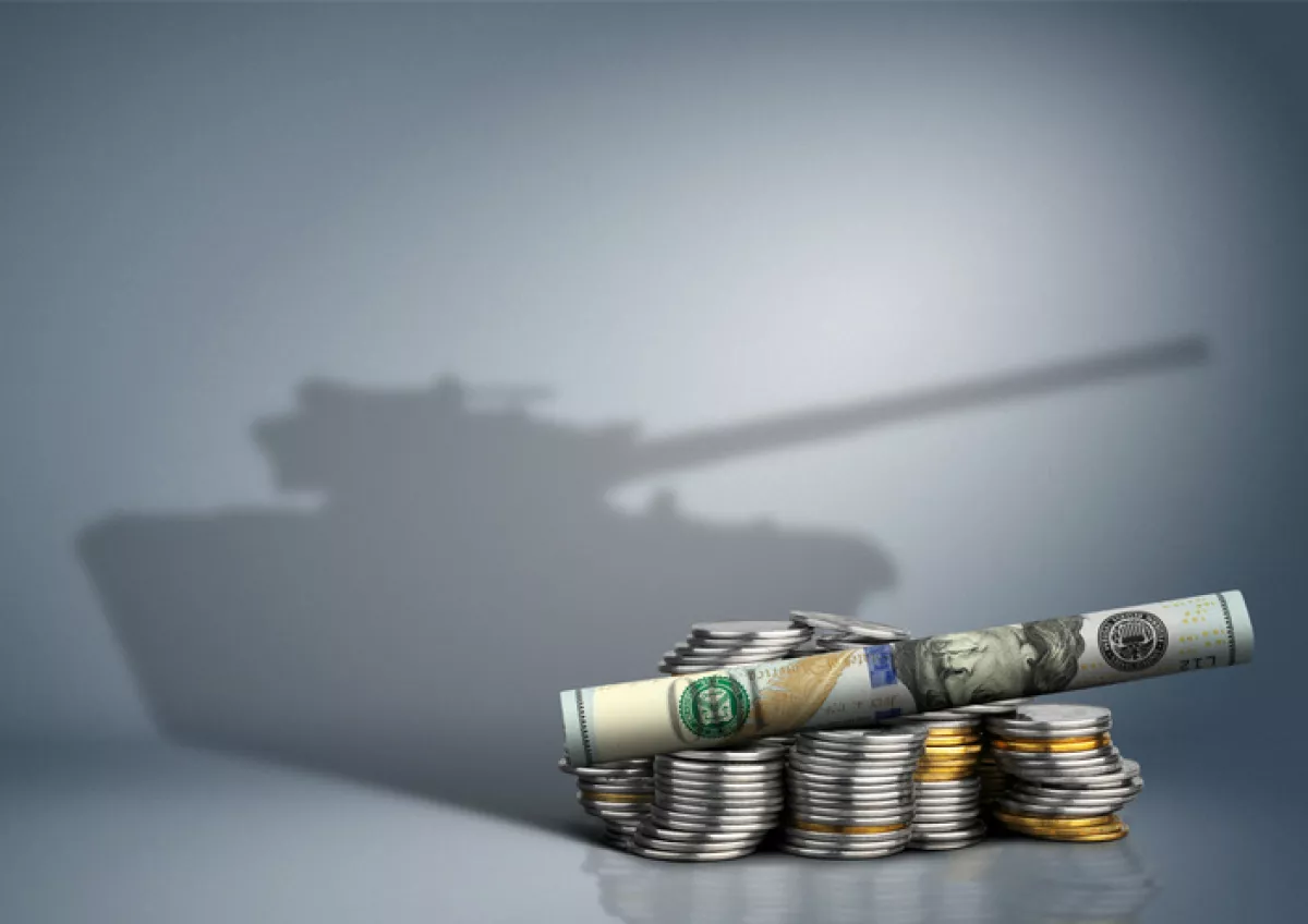 Billetes y monedas con tanque de guerra como sombra